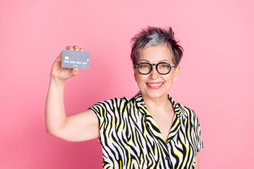 Poster - Photo of nice aged woman hold debit card wear zebra print shirt isolated on pink color background