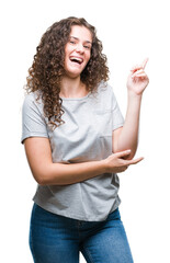 Beautiful young brunette curly hair girl wearing casual look over isolated background with a big smile on face, pointing with hand and finger to the side looking at the camera.