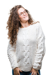 Beautiful brunette curly hair young girl wearing winter sweater over isolated background looking away to side with smile on face, natural expression. Laughing confident.