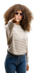 African american woman wearing a stripes sweater pointing with finger to the camera and to you, hand sign, positive and confident gesture from the front