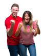 © Krakenimages.com - Young couple in love over isolated background very happy and excited doing winner gesture with arms raised, smiling and screaming for success. Celebration concept.