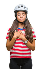 Wall Mural - Young arab cyclist woman wearing safety helmet over isolated background smiling with hands on chest with closed eyes and grateful gesture on face. Health concept.