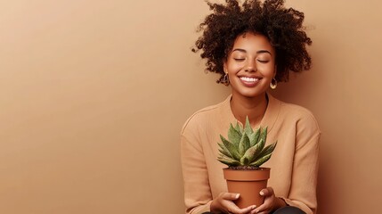 Woman with dark skin and curls holds a cactus, smiling.