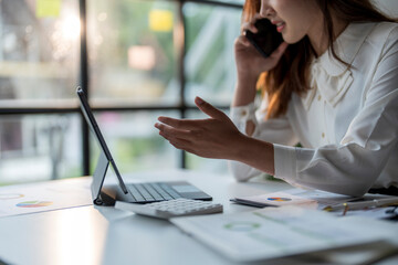 Wall Mural - businesswoman having video call on tablet and discussing financial charts