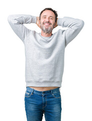 Wall Mural - Handsome middle age senior man wearing a sweatshirt over isolated background Relaxing and stretching with arms and hands behind head and neck, smiling happy