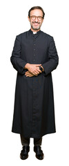 Wall Mural - Middle age priest man wearing catholic robe with a happy and cool smile on face. Lucky person.