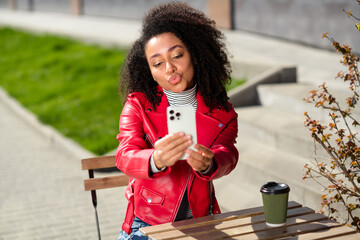 Poster - Photo of positive good mood woman dressed leather red jacket enjoying coffee sending kiss recording video outdoors urban city street