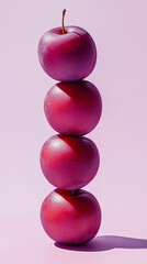 Wall Mural - A stack of plum fruit balancing on top with solid background