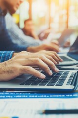 Wall Mural - A man is typing on a laptop in front of a group of people