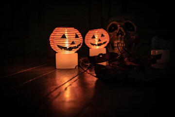 Halloween pumpkins with space for party invitation. Candle light with skeleton hand in the dark and dark atmosphere of witchcraft ritual