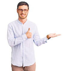 handsome young man with bear wearing elegant business shirt and glasses showing palm hand and doing 