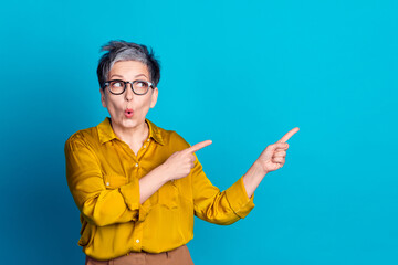 Wall Mural - Photo of impressed positive woman wear blouse eyeglasses showing fingers empty space isolated blue color background