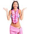 © Krakenimages.com - Young beautiful latin girl wearing bikini and hawaiian lei celebrating mad and crazy for success with arms raised and closed eyes screaming excited. winner concept