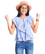 © Krakenimages.com - Young beautiful latin girl wearing summer hat and glasses screaming proud, celebrating victory and success very excited with raised arms