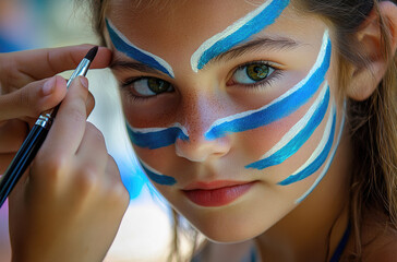 Sticker - Close-up of children's face painting artist drawing blue and white paint on the forehead