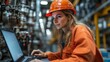 © OLKS_AI - A woman in a helmet with a laptop on the background of a factory floor