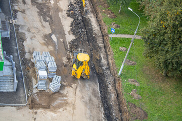 A bulldozer is actively loading soil into a sizable pile on a construction site