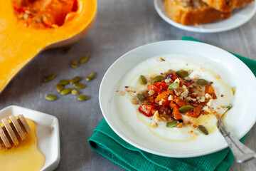 Healthy and nutritious autumn specific breakfast made of yogurt, baked pumpkin, nuts and seeds