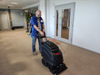 © Fox - A Caucasian man washes carpet from stains using a Carpet washing machine.