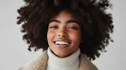 Wall Mural - Close up portrait of a happy young woman with curly hair smiling brightly.