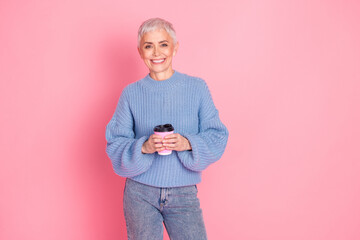 Canvas Print - Photo portrait of pretty retired female hold coffee paper cup wear trendy blue knitwear outfit isolated on pink color background