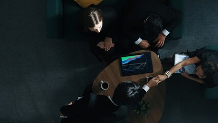 Wall Mural - Top down aerial view of skilled business man handed out business document to investor while manager placed tablet display financial statistic graph on table and shake hand with manager. Directorate.