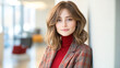 © Kowit - A woman in a red sweater and plaid jacket is posing for a picture