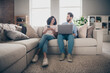 © deagreez - Photo of positive girl sit sofa couch spy guy look netbook in living room indoors