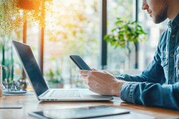 Sticker - A man is sitting at a desk with a laptop and a cell phone