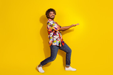 Sticker - Full length portrait of nice young man hold empty space wear shirt isolated on yellow color background