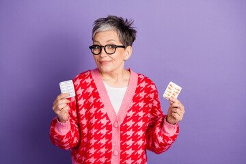 Wall Mural - Photo portrait of pretty retired female hold pills therapy wear trendy red outfit isolated on purple color background