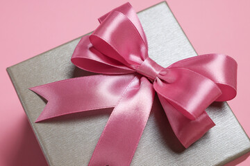 Poster - Gift box with bow on dusty pink background, closeup