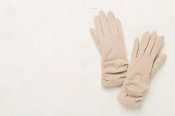 Wall Mural - Beige gloves on concrete background, top view