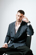 © Elina Leonova - Portrait of handsome man, fashion model. Sits on chair.