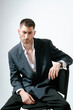 © Elina Leonova - Portrait of handsome man, fashion model. Sits on chair.