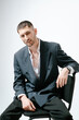 © Elina Leonova - Portrait of handsome man, fashion model. Sits on chair.