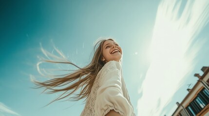 Joyful young woman smiling under a clear sky with flowing hair capturing a moment of freedom