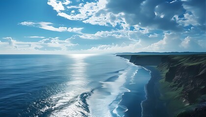 The beautiful coastline connects with the vast ocean, and against the blue sky and white clouds, it shows the majesty and tranquility of nature.