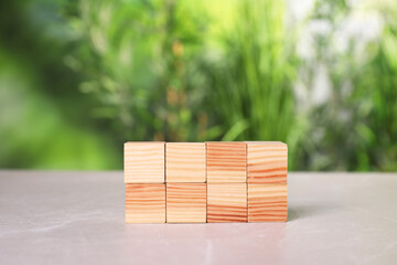 Poster - Many wooden cubes on light grey table outdoors