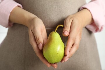 Canvas Print - Woman with fresh green pear on white background, closeup