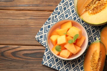 Wall Mural - Pieces of Cantaloupe melon and mint in bowl on wooden table, flat lay. Space for text