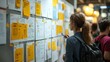 © BonzEarthsnapper - Colorful website wireframes pinned on a wall, collaborative design process, team brainstorming session.