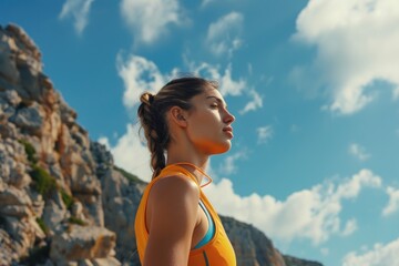 Wall Mural - A woman wearing a bright yellow top and blue shorts, likely engaging in outdoor activities