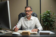 © Alfred - Middle-aged man reviewing documents at modern office desk