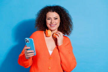 Wall Mural - Photo portrait of wavy haired model woman wearing orange bluetooth headphones dj player isolated on blue color background