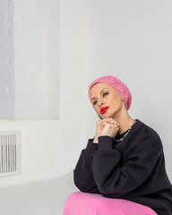 Portrait of beautiful woman in black jumper, pink skirt and beret in French style on light background. Vertical photo. High quality photo