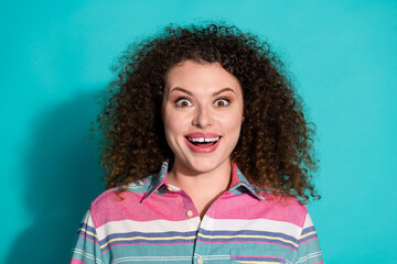 Photo portrait of young curly haired happy girl wearing striped stylish t shirt surprised reaction isolated on aquamarine color background