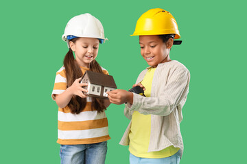 Poster - Cute little architects with house model and measuring tape on green background