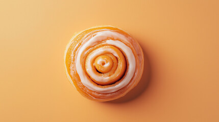 Wall Mural - a cinnamon bun with a swirl of icing on top against an isolated pastel orange background