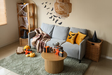 Poster - Interior of festive living room with grey sofa, Halloween decorations and gift boxes